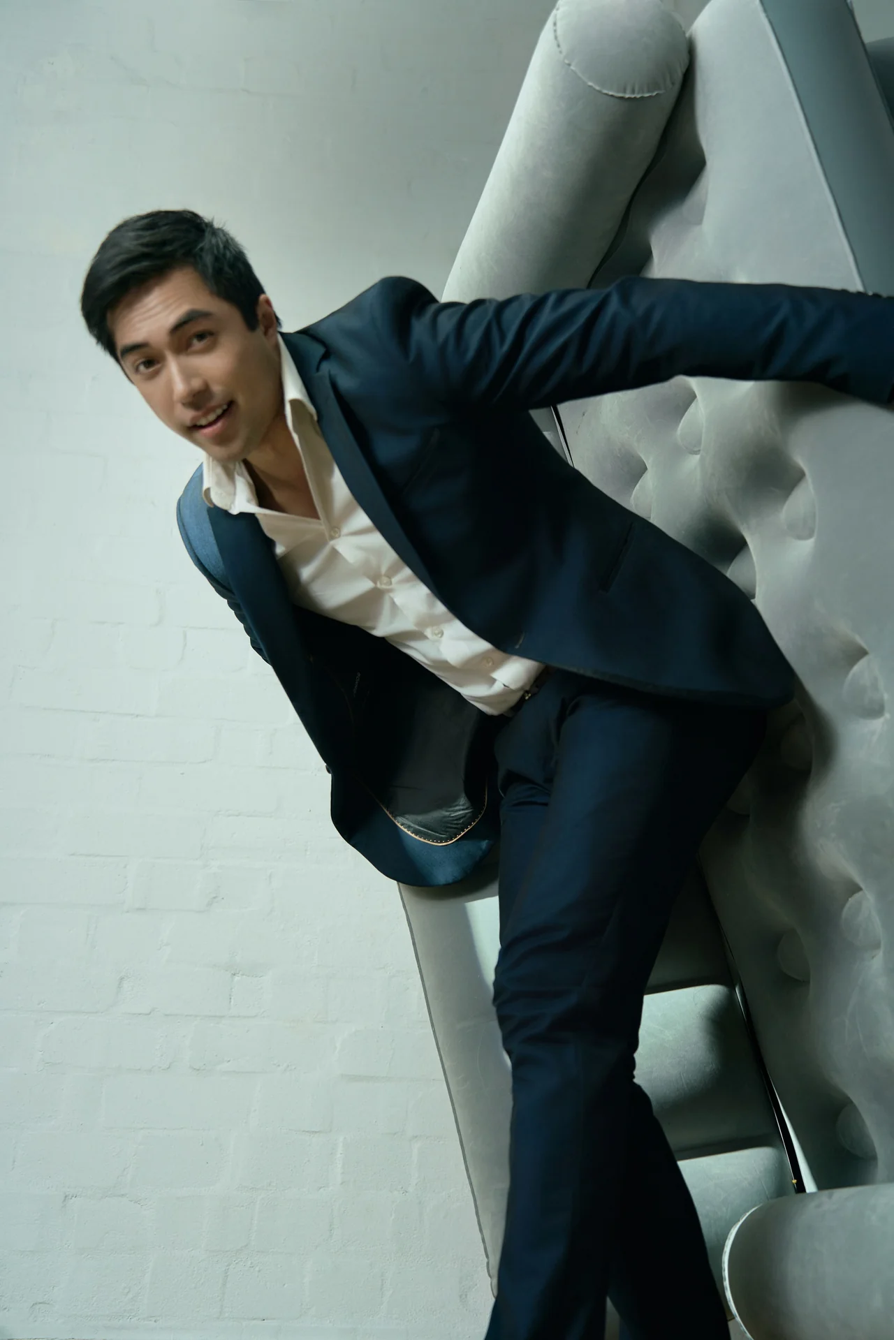 Damien Sato leaning forward in a dark suit
